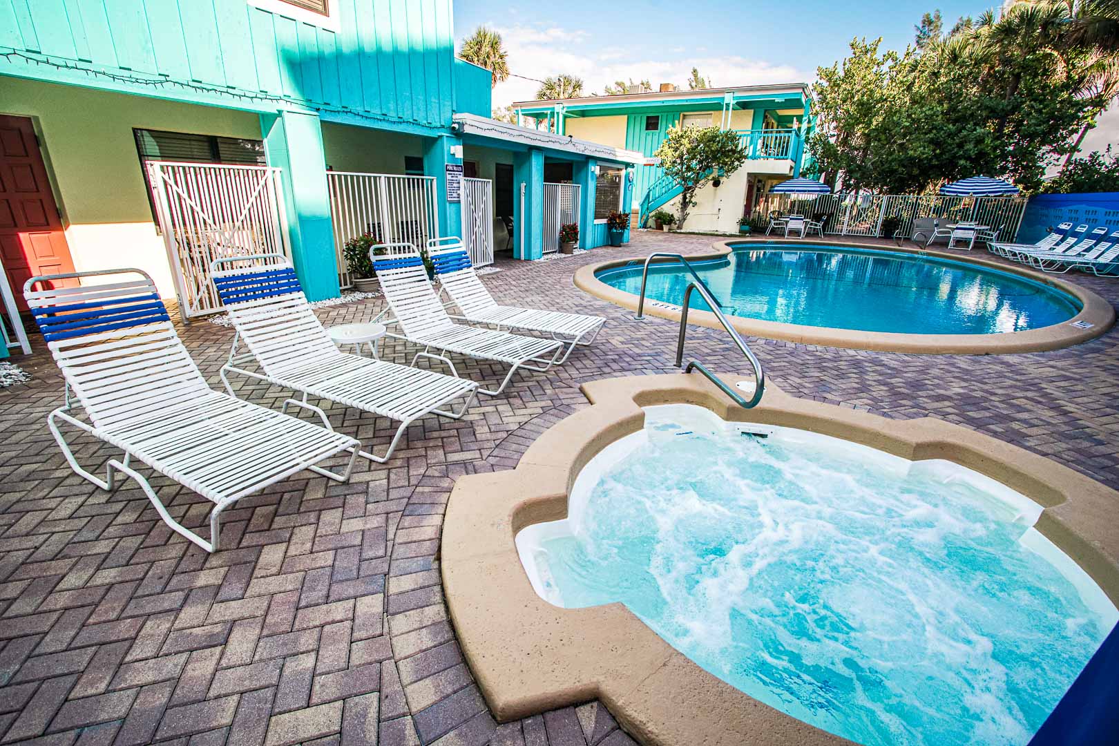 A colorful outdoor swimming pool and jacuzzi at VRI's Sand Dune Shores in Florida.